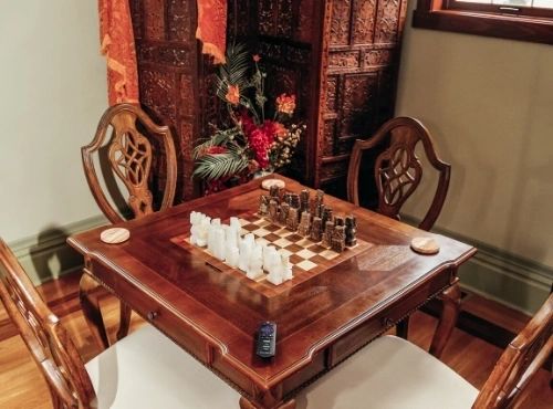 A wooden table with chess set on it