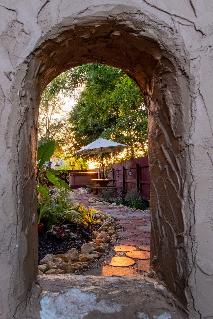 A stone arch leading to an outdoor patio.