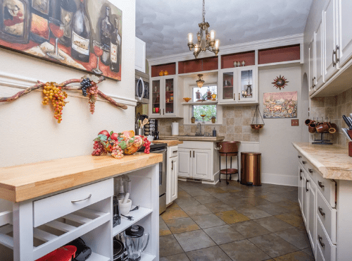 A kitchen with tile floors and white cabinets.