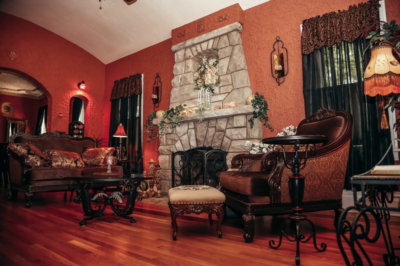 A living room with red walls and wooden floors.