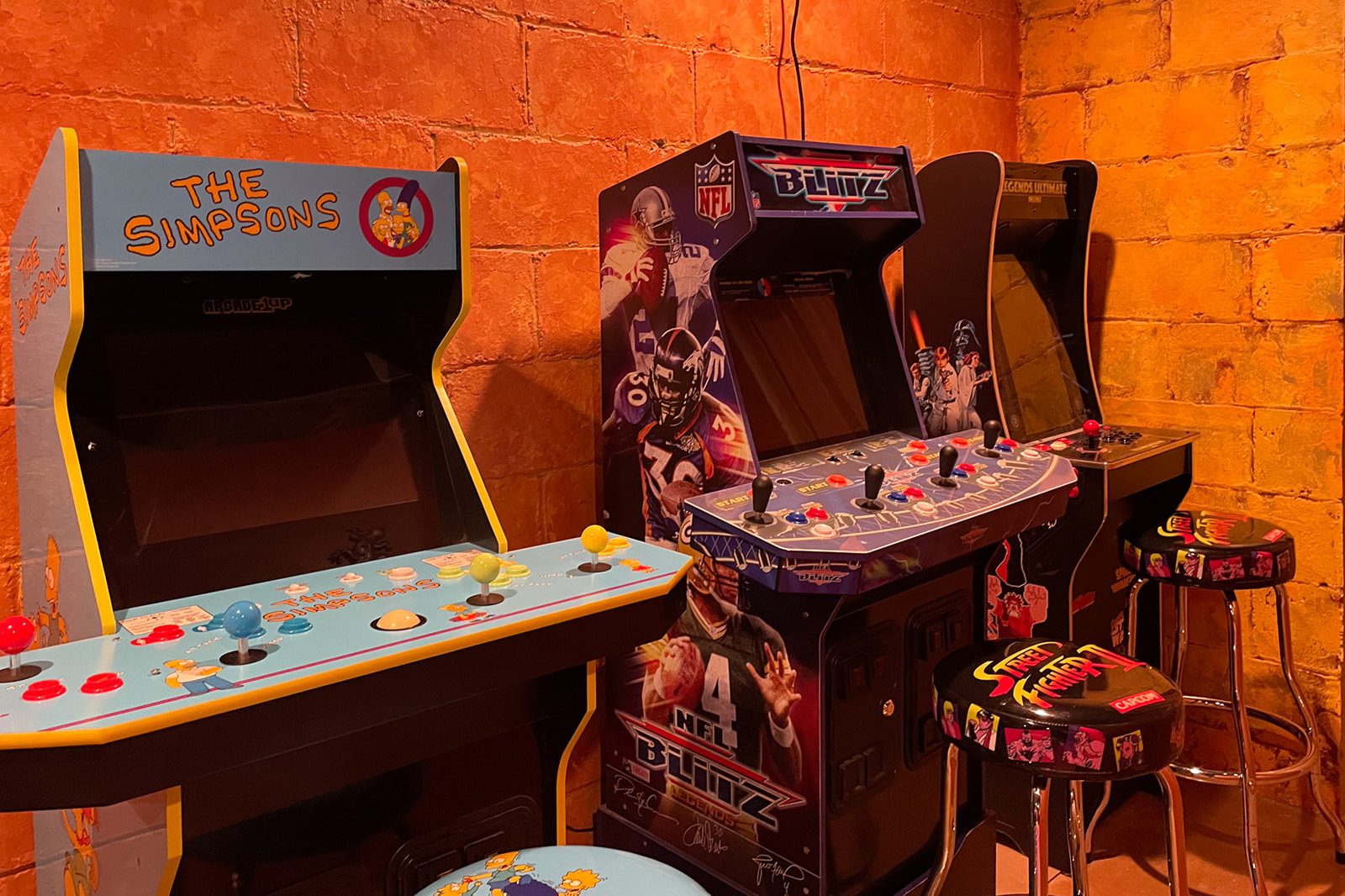 A room with several arcade machines and tables.